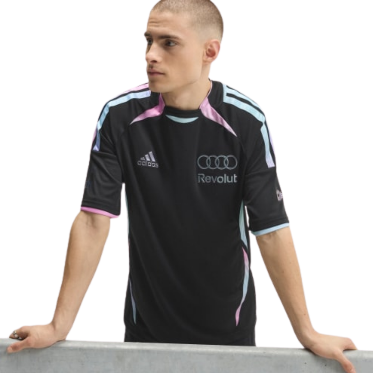 A black, pink, and light blue Audi F1 Team 2026 t-shirt featuring a crew neck with pink and light blue trim, curved gradient side panels, and official partner logos including Adidas and Revolut across the chest.