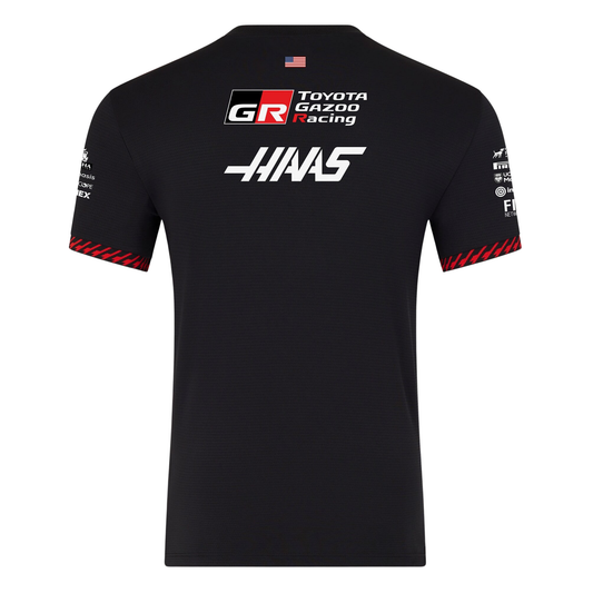 A black and red MoneyGram Haas F1 Team 2026 team t-shirt featuring a crew neck, red shoulder accents, and official partner logos including Haas, Toyota Gazoo Racing, and Orion180 across the chest.
