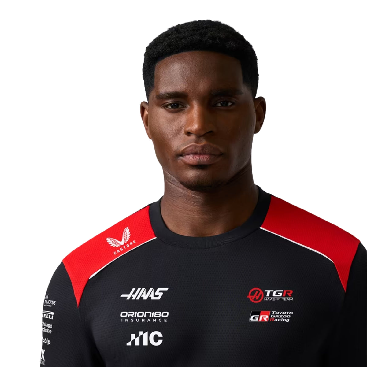A black and red Haas F1 2026 team t-shirt featuring a crew neck, red shoulder paneling, and official partner logos including MoneyGram Haas F1 Team, Toyota Gazoo Racing, and Orion180 across the chest.