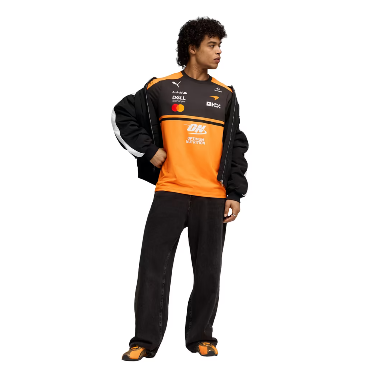 A papaya orange and charcoal McLaren F1 2026 team t-shirt featuring a crew neck and official partner logos including Android, Dell Technologies, OKX, and Optimum Nutrition across the chest.