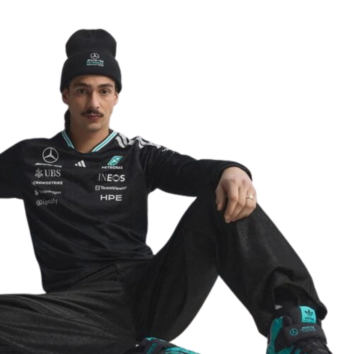 A black Mercedes-AMG Petronas 2026 team long-sleeve t-shirt featuring an all-over tonal geometric pattern, a V-neck collar with white shoulder stripes and vibrant teal inner trim, and official partner logos including Mercedes-AMG, Petronas, and UBS across the chest.