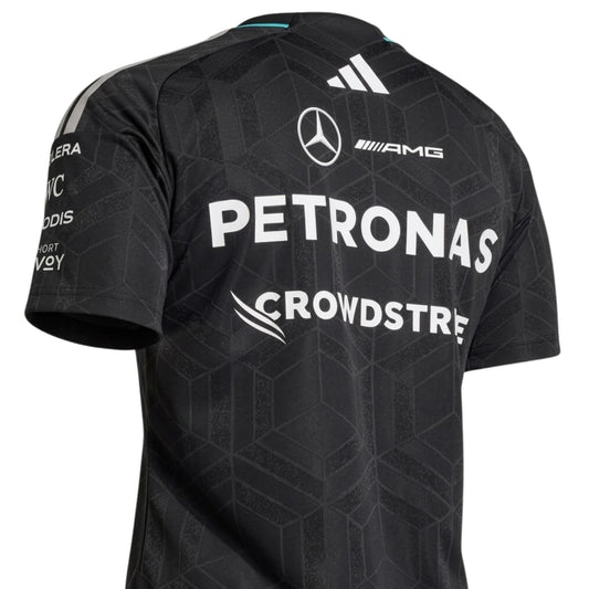 A black Mercedes-AMG Petronas F1 2026 team t-shirt featuring a subtle geometric pattern, a crew neck with teal accents, and official partner logos including UBS, Ineos, and CrowdStrike across the chest.