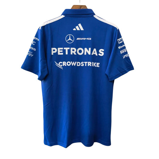 A royal blue Mercedes-AMG Petronas 2026 team polo shirt featuring a classic collar with white shoulder stripes, a button placket, and official partner logos including Mercedes-AMG, Petronas, and UBS across the chest.
