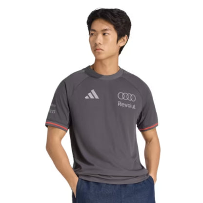 Official Audi 2026 team T-shirt in dark grey, featuring sponsor logos including Revolut, adidas, and Pirelli.