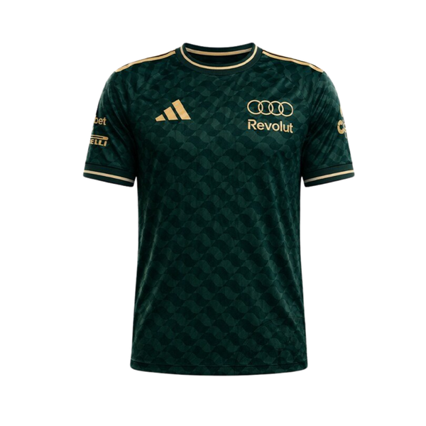 A green and gold Audi F1 Team 2026 t-shirt featuring an all-over geometric pattern, a crew neck with gold trim, and official partner logos including Audi and Revolut across the chest.