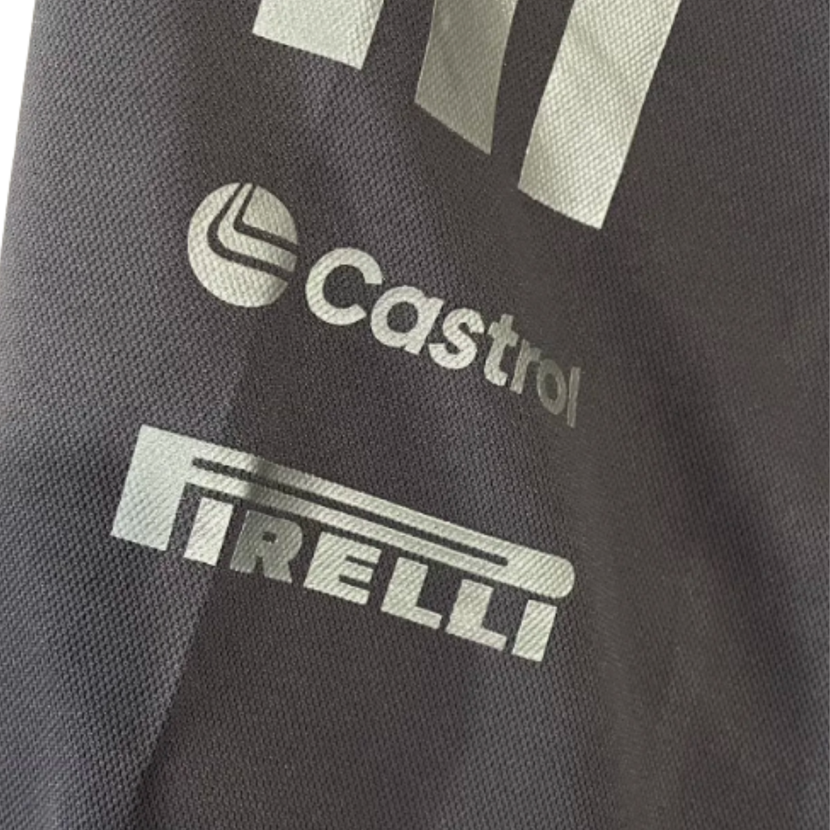Official Audi 2026 team polo shirt in dark grey, featuring sponsor logos including Revolut, adidas, and Castrol.