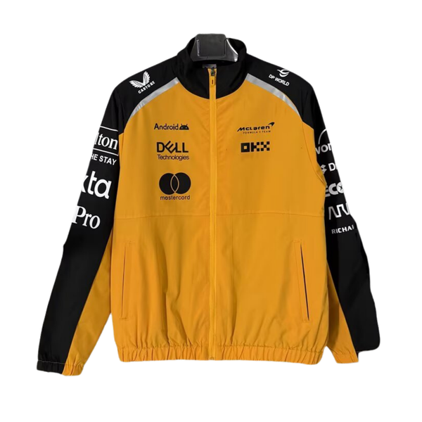 A papaya orange and black McLaren F1 2026 team windbreaker jacket featuring a full front zipper, stand-up collar, and sponsor logos including Android, Dell Technologies, and OKX across the chest.