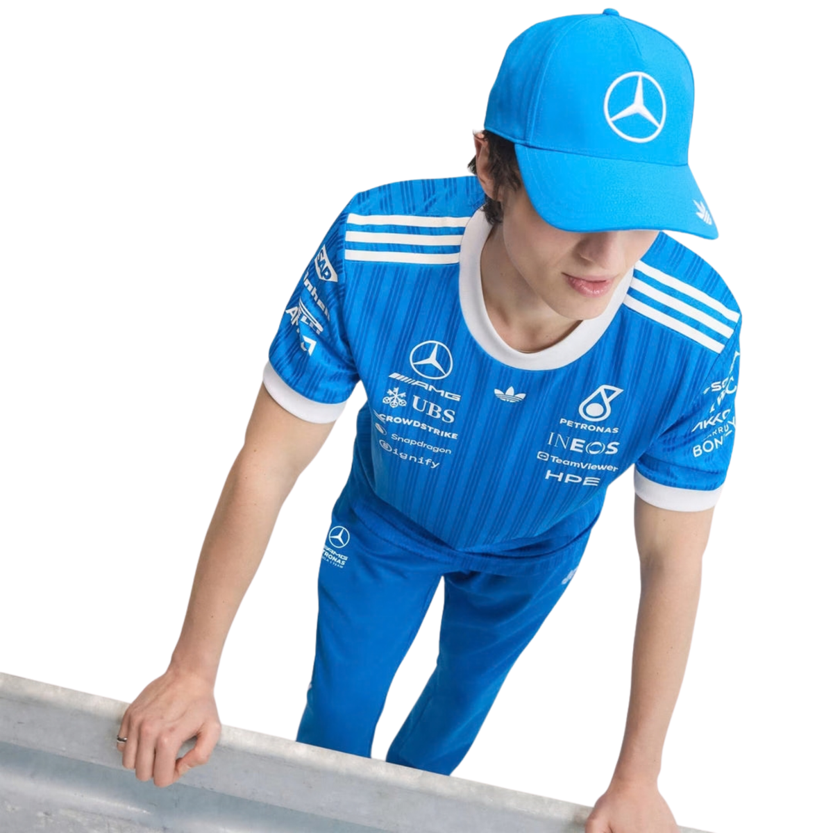 A blue and white Mercedes-AMG Petronas 2026 blue edition t-shirt featuring an all-over vertical pinstripe pattern, a white crew neck and sleeve cuffs, and official partner logos including Mercedes-AMG, Petronas, and UBS across the chest.