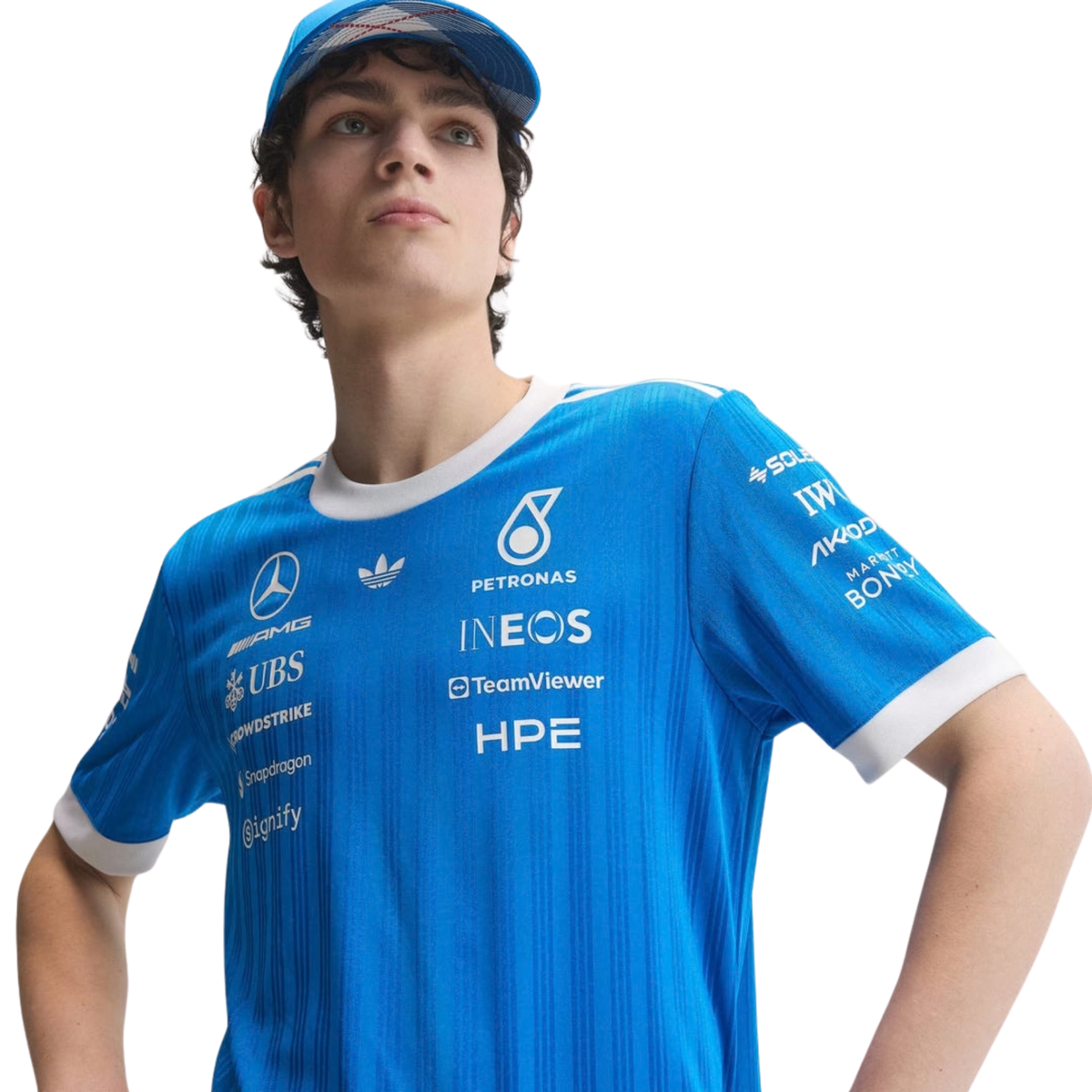 A blue and white Mercedes-AMG Petronas 2026 blue edition t-shirt featuring an all-over vertical pinstripe pattern, a white crew neck and sleeve cuffs, and official partner logos including Mercedes-AMG, Petronas, and UBS across the chest.