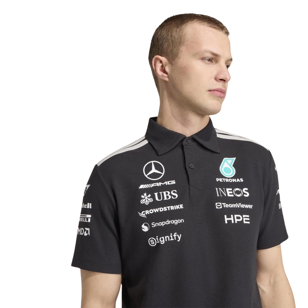Official Mercedes-AMG Petronas 2026 team polo shirt in dark grey, featuring sponsor logos including INEOS, UBS, and CrowdStrike.