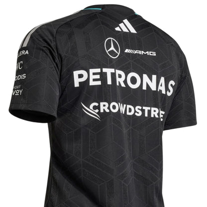 A black Mercedes-AMG Petronas F1 2026 team t-shirt featuring a subtle geometric pattern, a crew neck with teal accents, and official partner logos including UBS, Ineos, and CrowdStrike across the chest.