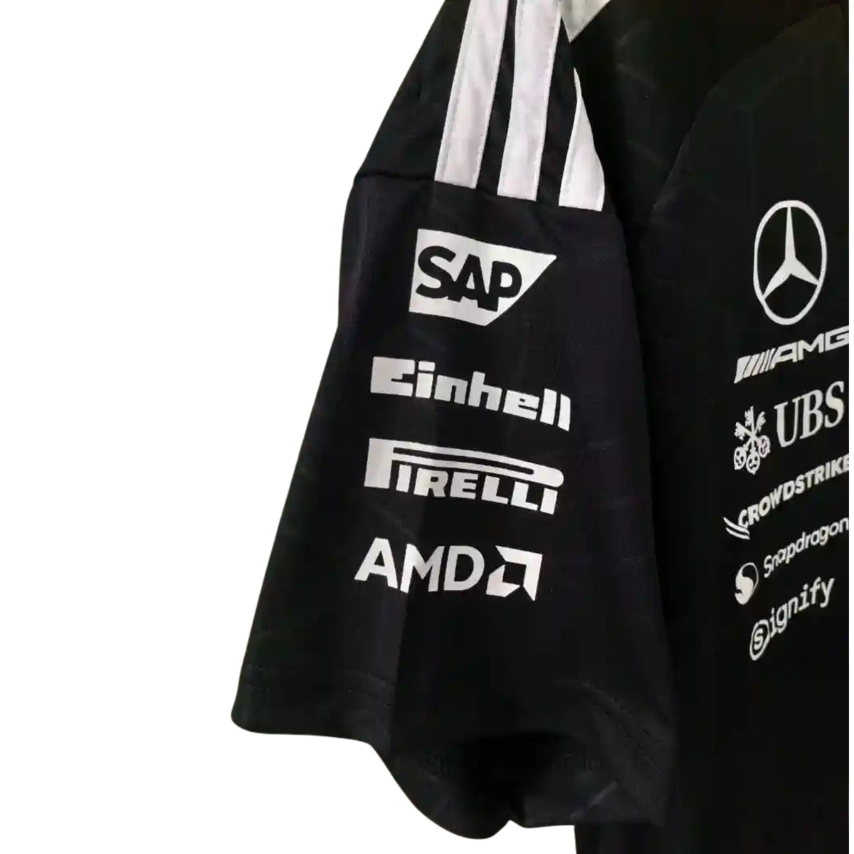 A black Mercedes-AMG Petronas F1 2026 team t-shirt featuring a subtle geometric pattern, a crew neck with teal accents, and official partner logos including UBS, Ineos, and CrowdStrike across the chest.