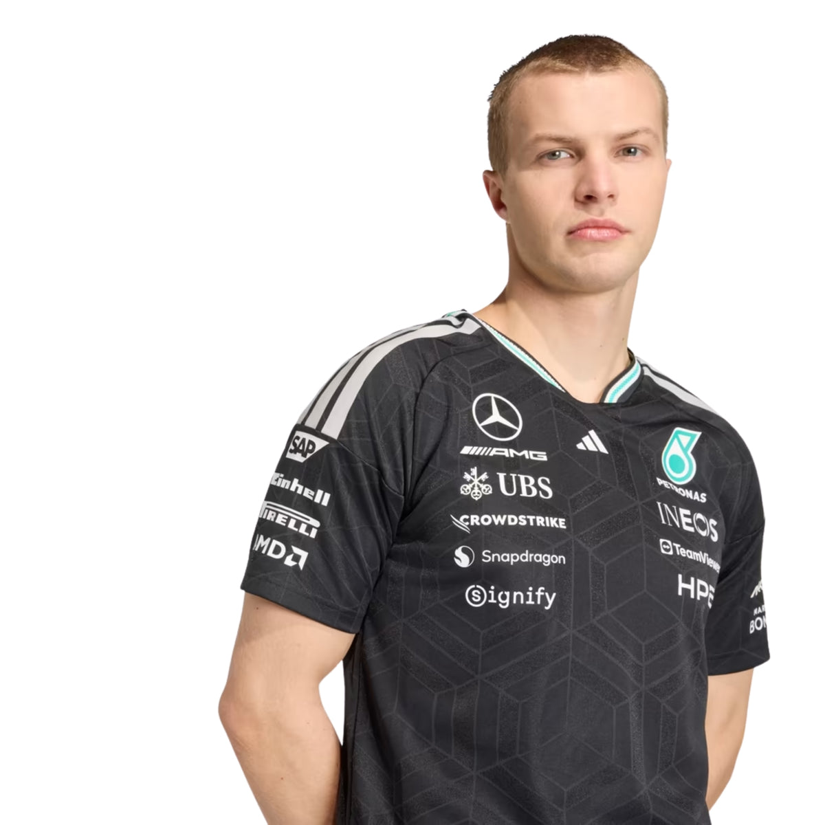 A black Mercedes-AMG Petronas F1 2026 team t-shirt featuring a subtle geometric pattern, a crew neck with teal accents, and official partner logos including UBS, Ineos, and CrowdStrike across the chest.