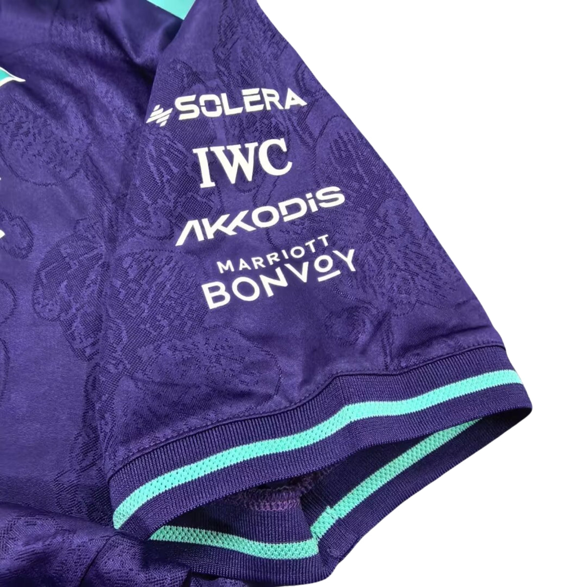 A special edition purple and teal Mercedes-AMG Petronas 2026 Singapore GP team t-shirt featuring an all-over tonal floral pattern, a crew neck with teal trim, and official partner logos including Mercedes-AMG, Petronas, and INEOS across the chest.