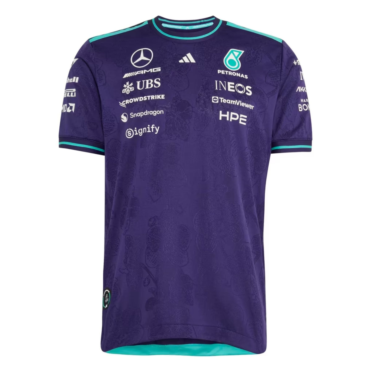 A special edition purple and teal Mercedes-AMG Petronas 2026 Singapore GP team t-shirt featuring an all-over tonal floral pattern, a crew neck with teal trim, and official partner logos including Mercedes-AMG, Petronas, and INEOS across the chest.