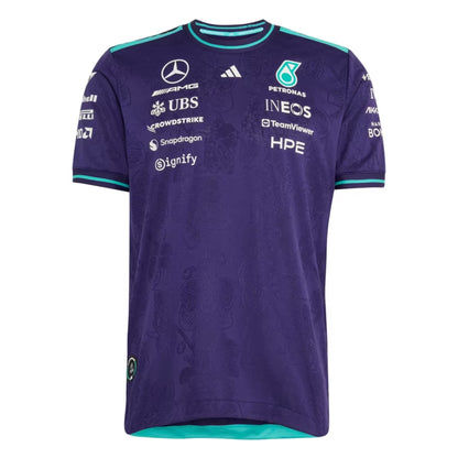 A special edition purple and teal Mercedes-AMG Petronas 2026 Singapore GP team t-shirt featuring an all-over tonal floral pattern, a crew neck with teal trim, and official partner logos including Mercedes-AMG, Petronas, and INEOS across the chest.