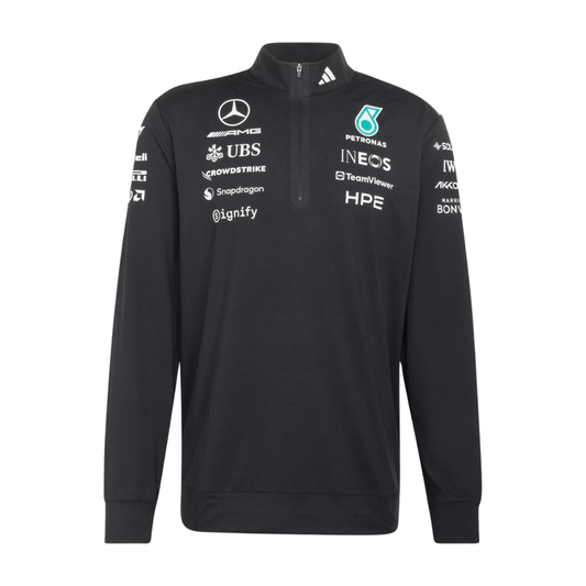 Model wearing a black Mercedes-AMG Petronas F1 2026 team 1/4-zip sweatshirt with sponsor logos including Adidas, UBS, and CrowdStrike
