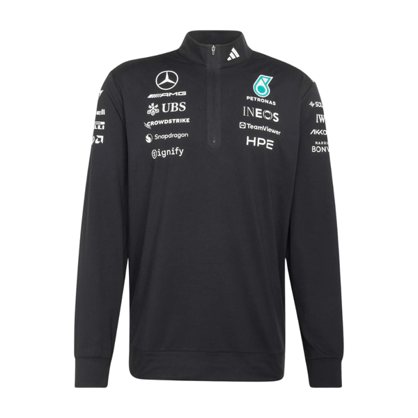 Model wearing a black Mercedes-AMG Petronas F1 2026 team 1/4-zip sweatshirt with sponsor logos including Adidas, UBS, and CrowdStrike