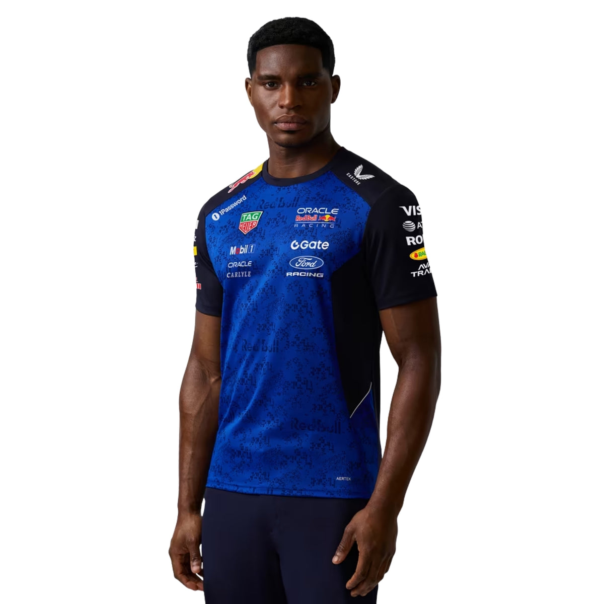 A navy blue and royal blue Oracle Red Bull Racing 2026 team t-shirt featuring a digital camouflage pattern, a crew neck, black sleeves, and prominent partner logos including TAG Heuer, Mobil 1, Ford Racing, and Oracle across the chest.