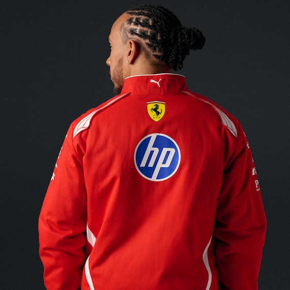 Official Scuderia Ferrari 2026 team racing jacket in red and white, featuring sponsor logos including HP, Shell, and UniCredit.