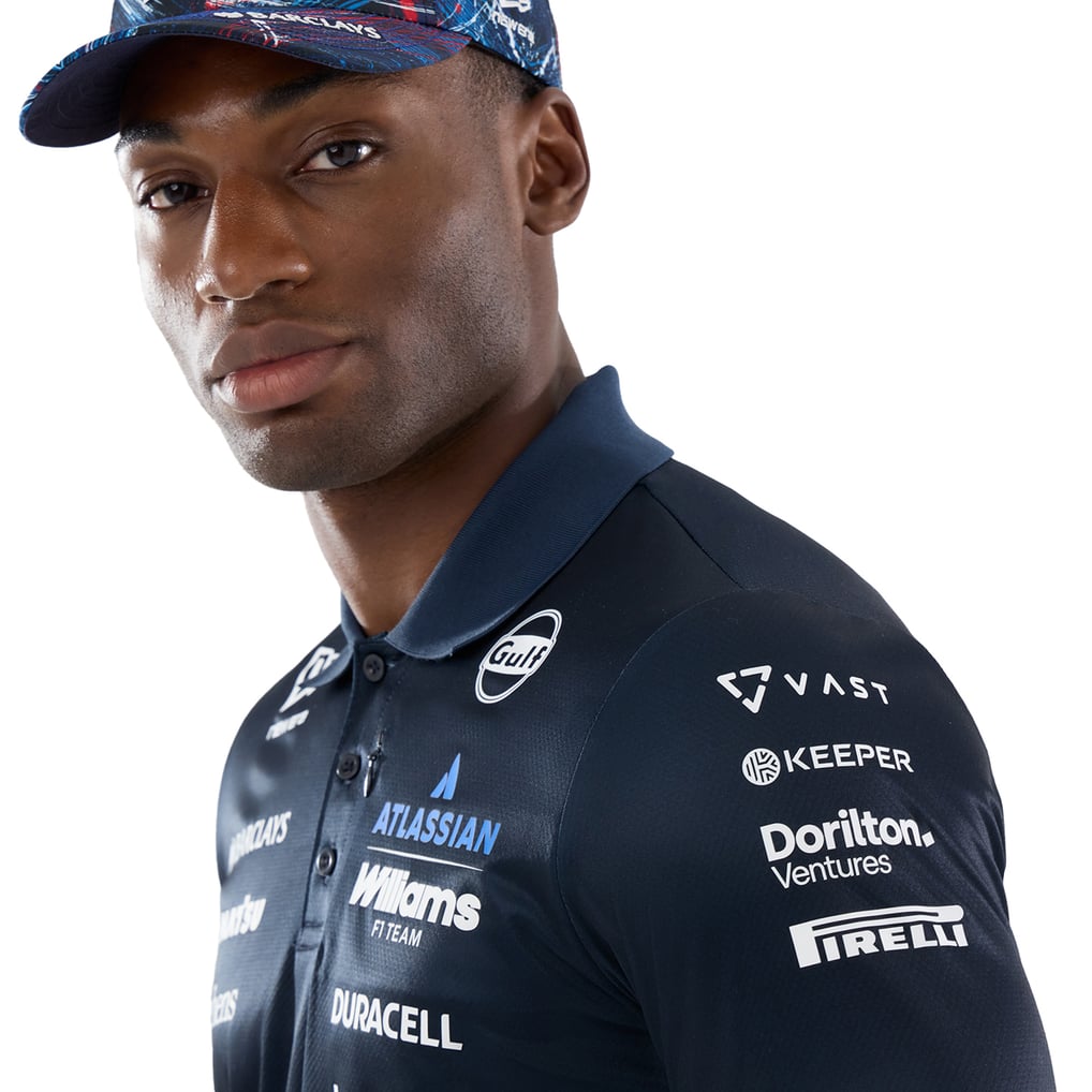 Official Williams Racing 2026 team polo shirt in navy blue and red, featuring sponsor logos including Gulf, Komatsu, and Duracell.